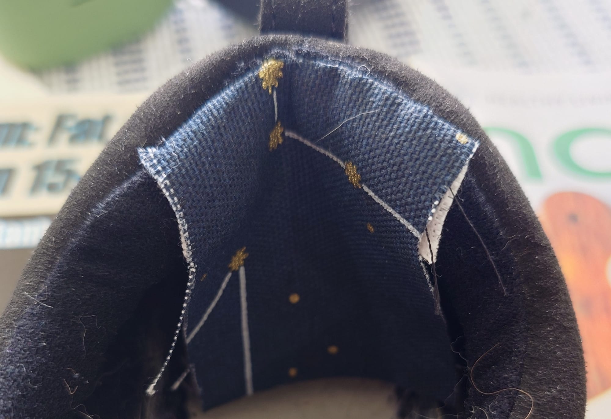 Dark blue fabric with constellation illustrations sewn into back of shoe.