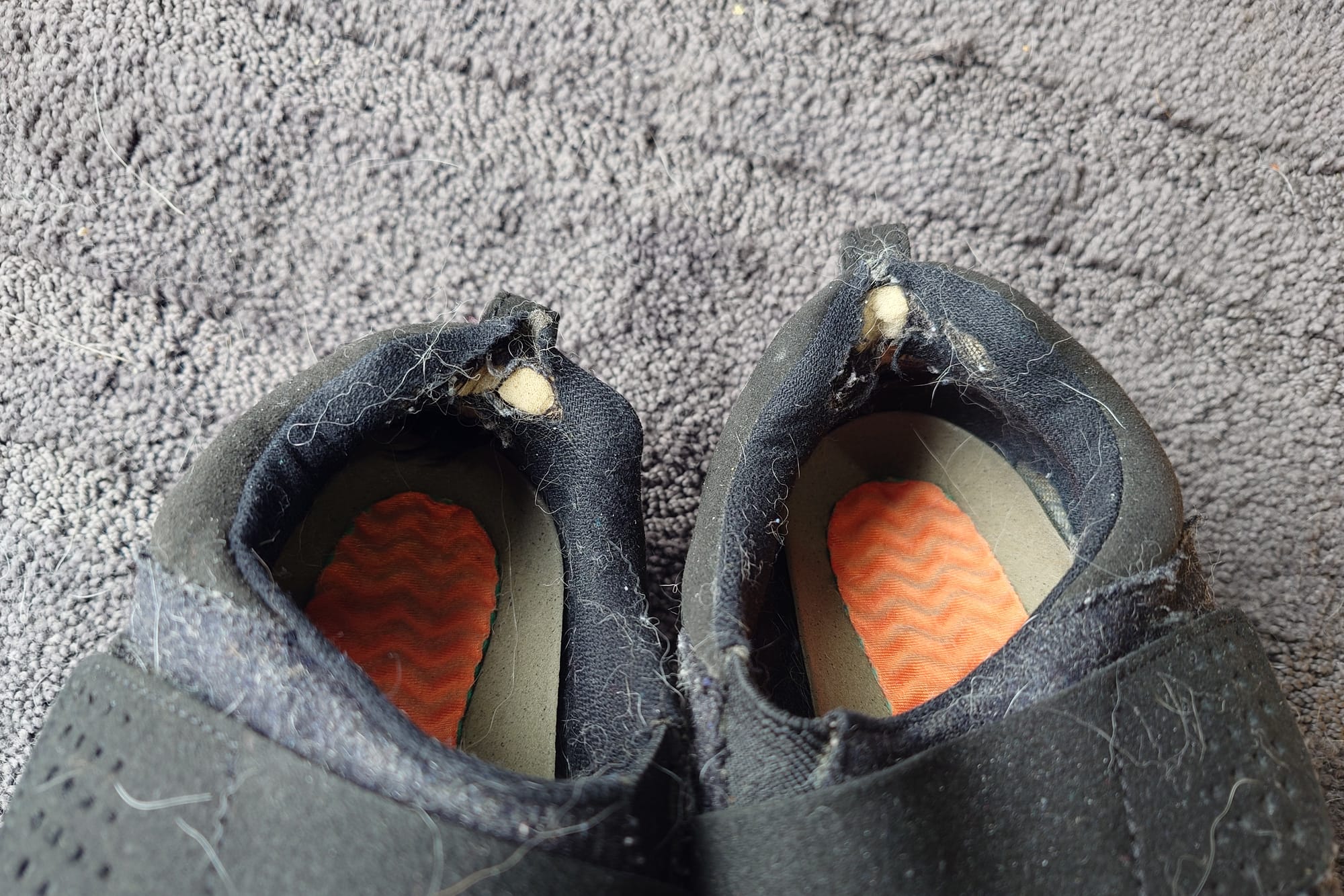 Image of the inside of the heels of the shoes. Worn areas are visible.