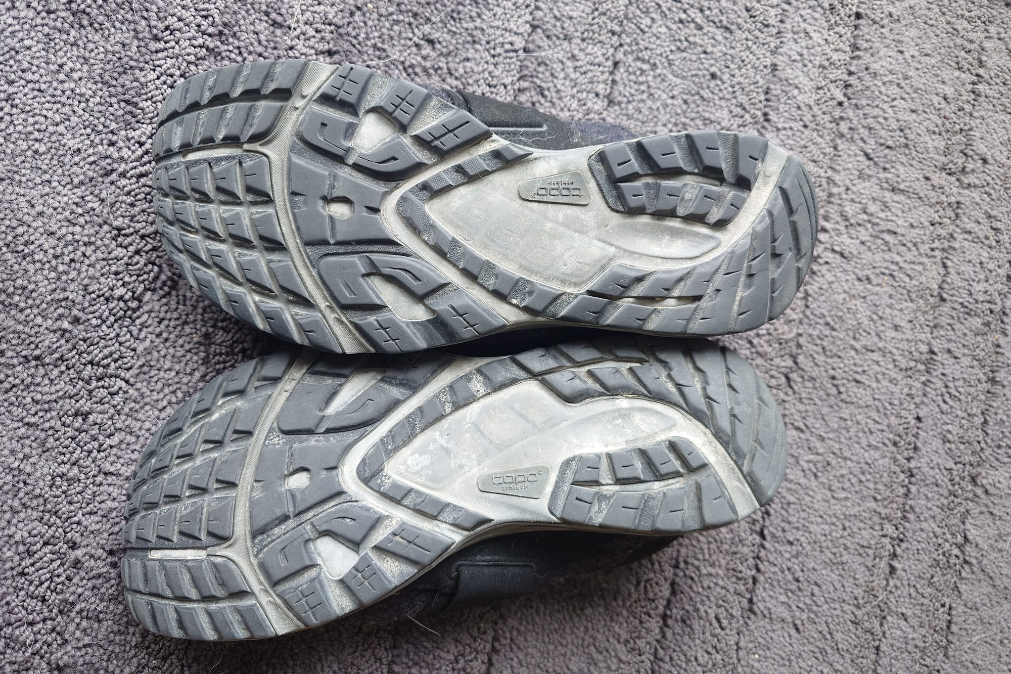 Soles and tread of shoes on a carpet background.